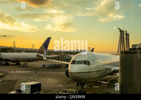 Newark, NJ - USA - 25. Juli 2022 Landschaftsaufnahme des Bodenbetriebs um zwei Jet-Flugzeuge, die am United Airlines Terminal C in Newark in geparkt sind Stockfoto
