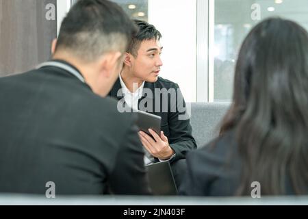 Seitenansicht eines asiatischen Geschäftsleits, der ein Meeting abhalten kann. Stockfoto