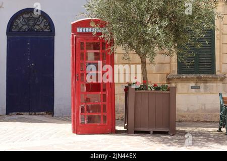 Ein britischer K6-Telefonkiosks, der sich vor der Polizeiwache auf dem Marktplatz in Nadur, Gozo, befindet. Stockfoto