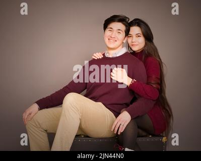Attraktive junge Biracial Paar in burgunderfarbenen Pullover posiert für Porträt Stockfoto