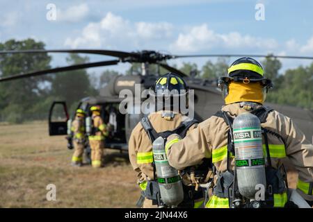 Feuerwehrleute der Lagerfeuerwehr Greyling führen im Rahmen des Northern Strike 22 im Greyling Army Airfield, Greyling, Michigan, am 6. August 2022 eine Probeausbildung zum Unfallplan durch. Northern Strike wurde entwickelt, um 7.400 Service-Mitglieder mit verschiedenen Schulungsformen herauszufordern, die die Interoperabilität zwischen mehreren Komponenten, multinationalen und behördenübergreifenden Partnern fördern. Stockfoto