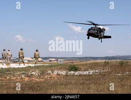 CAMP BONDSTEEL, Kosovo – Flieger der US-Armee aus dem Bataillon 2., 224. Aviation Regiment, 29. Combat Aviation Brigade, 29. Infantry Division, Virginia National Guard, führen im Camp Bondsteel, Kosovo, am 8. August 2022 eine Schlingentraining für nicht-Flugsoldaten durch. Die Soldaten des Liaison Monitoring Teams des Regionalkommandos Ost der Kosovo-Streitkräfte unternahmen die Schulung, um zu lernen, wie sie sicher Schleuderlasten durchführen können, was das schnelle Einsetzen von Vorräten und Ausrüstung selbst an den entlegensten Orten ermöglicht. (USA Armeefoto von Sgt. 1. Klasse Warren W. Wright Jr., 138. Public Affairs Stockfoto