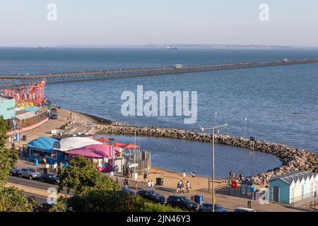 Three Shells Beach, eine von Menschen geschaffte Badelagune, Southend Pier und Strandpromenade sowie Schiffe in der Themse-Mündung mit der Kent-Küste im Hintergrund Stockfoto