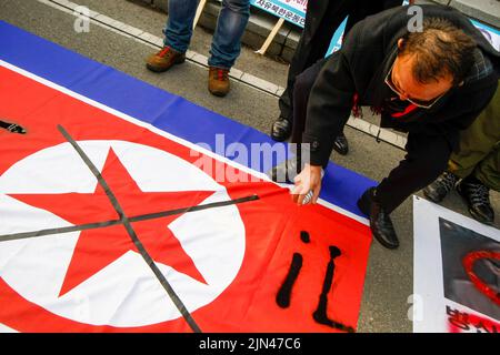 30. Nov 2010-Paju, Südkorea-südkoreanisches konservatives Gruppenmitglied beschädigt die nordkoreanische Flagge während einer nordkoreanischen Denunce-Flugblatt-Ballon-Veranstaltung im Imjingak Pavillion in Paju, Südkorea. Stockfoto