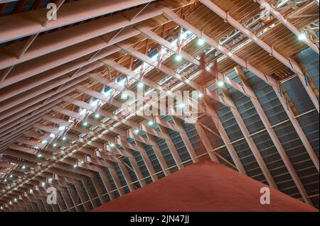 Gießen von roten Phosphatdüngern auf Stapel im Lagerhaus Stockfoto