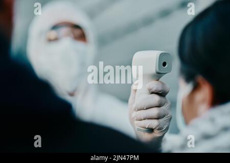 Medizinisches Fachpersonal, Scan-Temperatur von covid Patient für die Sicherheit vor Virus-Pandemie, tragen Schutzanzug. Arzt in Hazmat Anzug Stockfoto