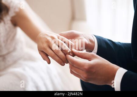 Mein Herz gehört Ihnen und wird es immer sein. Ein unkenntlich gezeihtes Bräutigam, das während ihrer Hochzeit einen Diamantring auf den Finger seiner Frau legt. Stockfoto