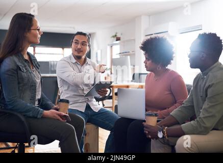 Die führenden Innovatoren in der Kreativbranche. Eine Gruppe junger Geschäftsleute, die sich in einem modernen Büro treffen. Stockfoto