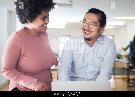 Tolle Ideen von tollen Teamkollegen. Eine junge Geschäftsfrau und ein Geschäftsmann mit einem Laptop in einem modernen Büro. Stockfoto