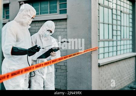 Medizinische Mitarbeiter im Gesundheitswesen arbeiten gemeinsam gegen die Ausbreitung des Covid-Virus und tragen Schutzkleidung. Ärzte in Hazmat Anzüge tun Stockfoto