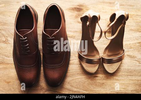 Waren bereit, den Gang hinunter zu gehen. Stillleben einer Braut und eines Bräutigams Hochzeit Schuhe nebeneinander auf einer hölzernen Oberfläche. Stockfoto