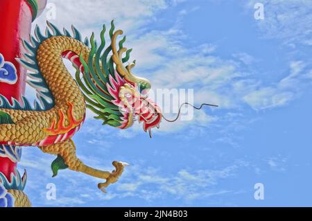 Goldene fliegende majestätische asiatische chinesische Drachenstatue mit blauem Himmel an sonnigen Tagen Stockfoto