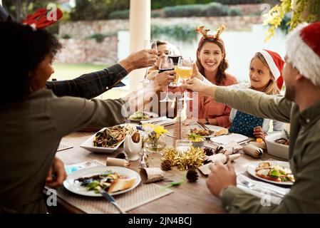 Nichts bringt Familie zusammen wie Weihnachten. Eine Familie, die am Weihnachtstag anstostet. Stockfoto