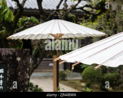 Nankoku, Präfektur Kochi, Japan - 6. April 2018: Japanische Regenschirme aus weißem Papier schmücken einen Garten bei Kokubunji, Tempel Nummer 29 des Shikoku Pilgers Stockfoto