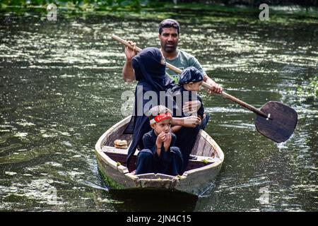 Srinagar, Indien. 08. August 2022. Ein Bootsmann bringt Kashmiri-schiitische Trauerlinge während einer religiösen Prozession in den Innenräumen des Dal-Sees in Srinagar an. Muharram ist ein Monat der Trauer zum Gedenken an das Martyrium von Imam Hussain, dem Enkel des Propheten Muhammad (PBUH). Kredit: SOPA Images Limited/Alamy Live Nachrichten Stockfoto