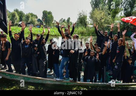 Srinagar, Indien. 08. August 2022. Schiitische Muslime aus Kaschmir rufen während einer Muharram-Prozession im Inneren des Dal-Sees in Srinagar religiöse Parolen auf, während sie auf Booten fahren. Muharram ist ein Monat der Trauer zum Gedenken an das Martyrium von Imam Hussain, dem Enkel des Propheten Muhammad (PBUH). Kredit: SOPA Images Limited/Alamy Live Nachrichten Stockfoto