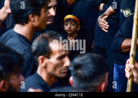 Srinagar, Indien. 08. August 2022. Ein junger schiitischer Kaschmiri-Muslim nimmt an einem Trauerritual während einer religiösen Prozession in den Innenräumen des Dal-Sees in Srinagar Teil. Muharram ist ein Monat der Trauer zum Gedenken an das Martyrium von Imam Hussain, dem Enkel des Propheten Muhammad (PBUH). Kredit: SOPA Images Limited/Alamy Live Nachrichten Stockfoto