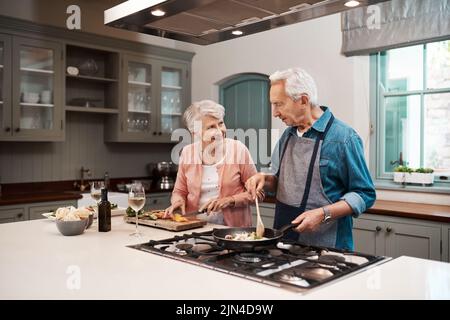 Je älter Sie werden, desto stärker sollte Ihre Ehe sein. Ein Seniorenpaar kocht zu Hause zusammen. Stockfoto