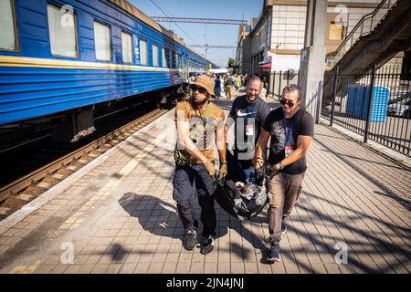 6. August 2022, Donezk Oblast, Donets'ka Oblast'', Ukraine: Freiwillige bringen eine Frau mit Gehbehinderung in den Evakuierungszug. Inmitten der intensivierten Kämpfe im östlichen Teil der Ukraine intensiviert die Ostukraine nun ihre zivile Evakuierung, da Millionen ukrainischer Familien aus dem immer näher rückt Krieg evakuiert wurden, da viele von ihnen in den westlichen Teil des Landes verlagert werden.Laut den Vereinten Nationen werden die meisten von ihnen in den Westen des Landes umgesiedelt. Mindestens 12 Millionen Menschen sind seit dem russischen Einmarsch in die Ukraine aus ihrer Heimat geflohen, während sieben Millionen Menschen innerhalb des Landes vertrieben werden. Stockfoto