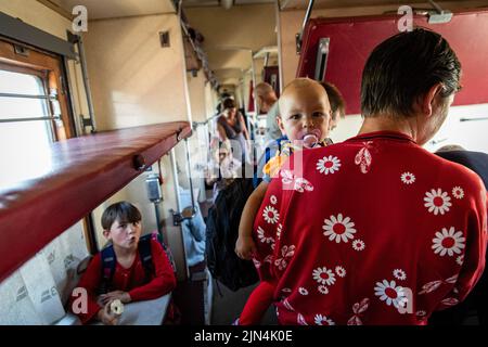 6. August 2022, Donezk, Donezk, Ukraine: Eine Mutter geht mit ihrem Baby in den Evakuierungszug am Bahnhof Pokrowsk. Inmitten der intensivierten Kämpfe im östlichen Teil der Ukraine intensiviert die Ostukraine nun ihre zivile Evakuierung, da Millionen ukrainischer Familien aus dem immer näher rückt Krieg evakuiert wurden, da viele von ihnen in den westlichen Teil des Landes verlagert werden.Laut den Vereinten Nationen werden die meisten von ihnen in den Westen des Landes umgesiedelt. Mindestens 12 Millionen Menschen sind seit dem russischen Einmarsch in die Ukraine aus ihrer Heimat geflohen, während sieben Millionen Menschen innerhalb des Landes vertrieben werden. (Cr Stockfoto