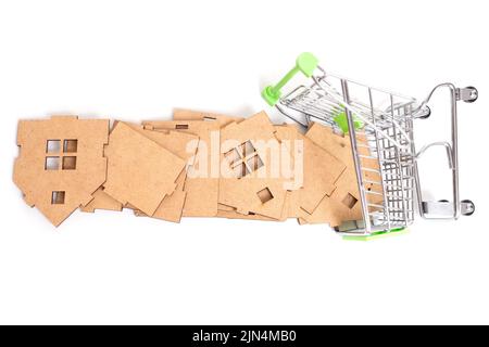 Umgedrehter Miniatur-Push-Trolley und hölzerne Spielzeughausteile isoliert auf weißem Hintergrund. Bauindustriebezogenes Konzept. Stockfoto