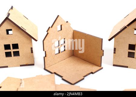 Vorgefertigtes Immobilienkonzept. Spielzeughäuser und Teile auf Weiß. Stockfoto