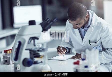 Wissenschaftler, Forscher und Medizintechniker schreiben auf einem Tablet und zeichnen Informationen und Ergebnisse in einem Labor auf. Zielgerichtete und seriöse Mitarbeiter verwenden Stockfoto