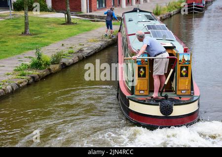 Chester, Großbritannien: 3. Jul 2022: Ein Paar manövriert vorsichtig sein Schmalboot im Chester Canal Basin des Shropshire Union Canal Stockfoto