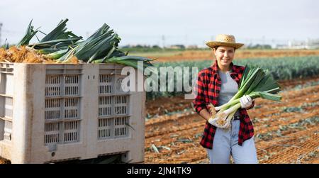 Frau posiert mit Lauch Ernte auf dem Feld Stockfoto