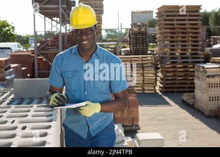 afroamerikanischer Manager, führt Aufzeichnungen über Baumaterialien Stockfoto