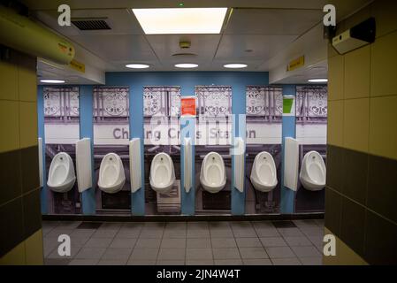 Reihe von Urinalen in Charing Cross Station. Herren-WC im Bahnhof Charing Cross mit detailliertem Foto-Backsplash Stockfoto