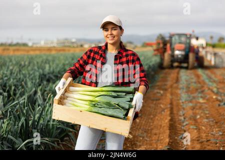 Frau posiert mit Lauch Ernte auf dem Feld Stockfoto