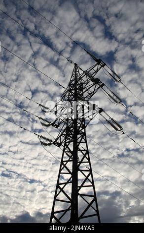 Silhouette der Hochspannungsleitung unter bewölktem Himmel Stockfoto