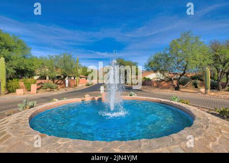 Drehstraße mit Springbrunnen in der Mitte an den Vororten von Tucson, Arizona. In der Mitte befindet sich ein Springbrunnen gegen den Blick von Tall Stockfoto