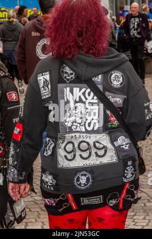 Dekorierte Jacken, T-Shirts, Anti-Establishment- und exzentrische Slogans und Bandnamen beim Rebellion Music Event, dem weltweit größten Punk-Festival in Blackpool. Anfang August finden in den Winter Gardens von Blackpool zahlreiche Punk-Bands statt, die 21. zum Rebellion Festival eingeladen wurden, das Tausende von Touristen in das Resort zieht. Über 4 Tage im August treffen sich in Blackpool die besten Punk-Künstler zu diesem gesellschaftlichen Ereignis des Jahres mit 4 Tagen Musik auf 6 Bühnen und einer Vielzahl von Bands. Stockfoto