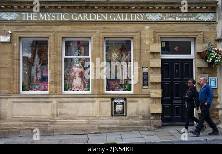 Ein paar, die an einem Laden in Glastonbury's High-Street vorbeigehen Stockfoto