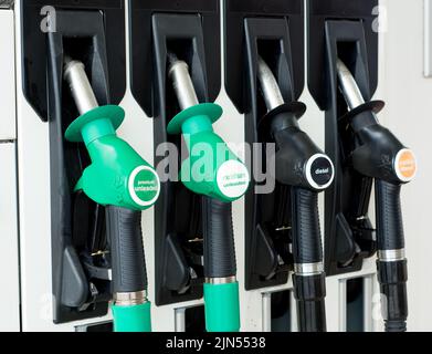 Ansicht von vier Benzin- und Dieseldüsen in Position auf dem Pumpenverteiler an einer Tankstelle im Großraum London, Großbritannien. Stockfoto