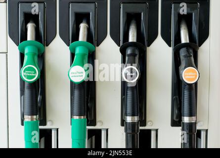 Ansicht von vier Benzin- und Dieseldüsen in Position auf dem Pumpenverteiler an einer Tankstelle im Großraum London, Großbritannien. Stockfoto