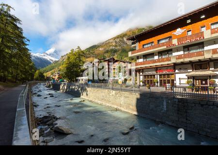 Zermatt, Schweiz - 7. Oktober 2019: Blick auf die Straße der Stadt im berühmten Skigebiet Schweizer Alpen, Fluss, Matterhorn Schneegipfel Stockfoto