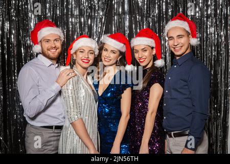 Gerne Freunde in santa Hüte auf Weihnachtsfeier Stockfoto