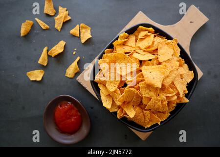 Tortilla Chip ist Maischips oder Call Nachos, serviert in einer Schüssel, auf schwarzem Hintergrund aus Mais Stockfoto