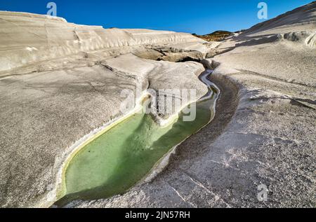 Einzigartige weiße Felsen am Strand von Sarakiniko und einem natürlichen, eingeklemmten Wasserbecken auf der Insel Milos, Griechenland. Leere Klippen, Sommersonne, klarer blauer Himmel Stockfoto