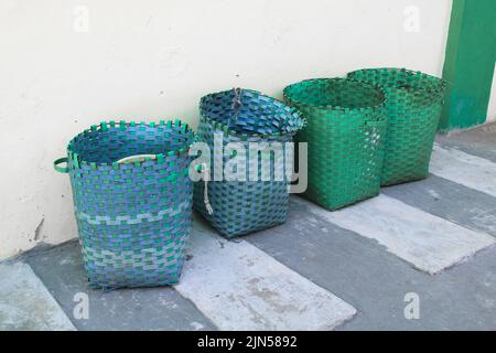 Korb, Plastikkorb dient als Mülleimer.Mülleimer kann draußen gegen die Wand Stockfoto