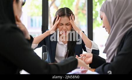 Verärgerte und verrückte, tausendjährige asiatische Geschäftsfrau oder weibliche Chefin beim Treffen mit ihrem unprofessionellen Team. Stockfoto