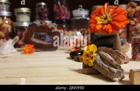 Agatisierte Koralle mit Quarzkristallen und Blumen auf Meditationsaltar Stockfoto