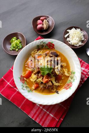 'Goat Curry oder Gulai Kambing, Lebensmittel aus asien. Köstliches Ziegenfleisch-Curry, serviert in einem bowl.served mit Tomaten, Gewürzen, Sellerie und Kohl Stockfoto