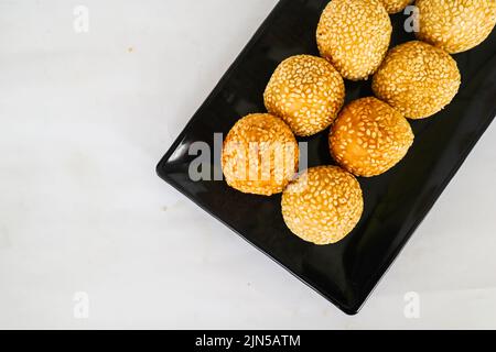 onde-onde oder Sesamball oder Jian Dui ist gebratenes chinesisches Gebäck, das aus klebrigem Reismehl hergestellt und mit Sesamsamen überzogen ist, die mit Bohnenpaste gefüllt sind. Stockfoto