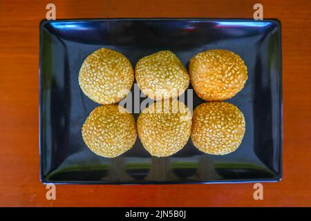 onde-onde oder Sesamball oder Jian Dui ist gebratenes chinesisches Gebäck, das aus klebrigem Reismehl hergestellt und mit Sesamsamen überzogen ist, die mit Bohnenpaste gefüllt sind. Stockfoto