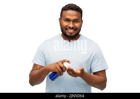 Glücklicher afrikanischer Mann, der Rasierschaum auf die Hand applyte Stockfoto