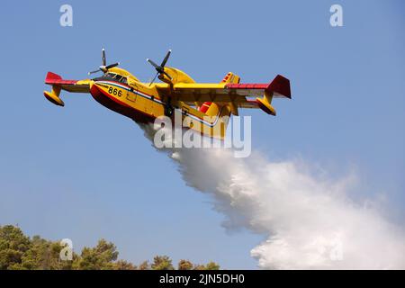 Die kroatische Luftwaffe Canadair CL-415 gibt Wasser frei, während sie einen Brand während eines Waldbrands auf der Halbinsel Peljesec im Süden Kroatiens löscht. Stockfoto